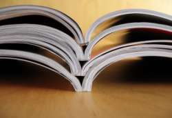 Pile of open books on table.